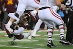 Minnesota Gophers linebacker Donald Willis (20) tackles Wisconsin Badgers tight end Hayden Rucci (87) during the second quarter of an NCAA football ga