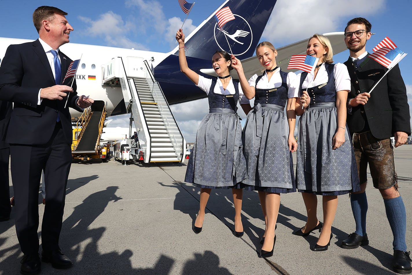 Timothy Liston, U.S. Consul General in Munich, smiles with a Lufthansa crew in traditional Bavarian costume prior to a flight bound for Miami at Munich Airport on Nov. 8, 2021.