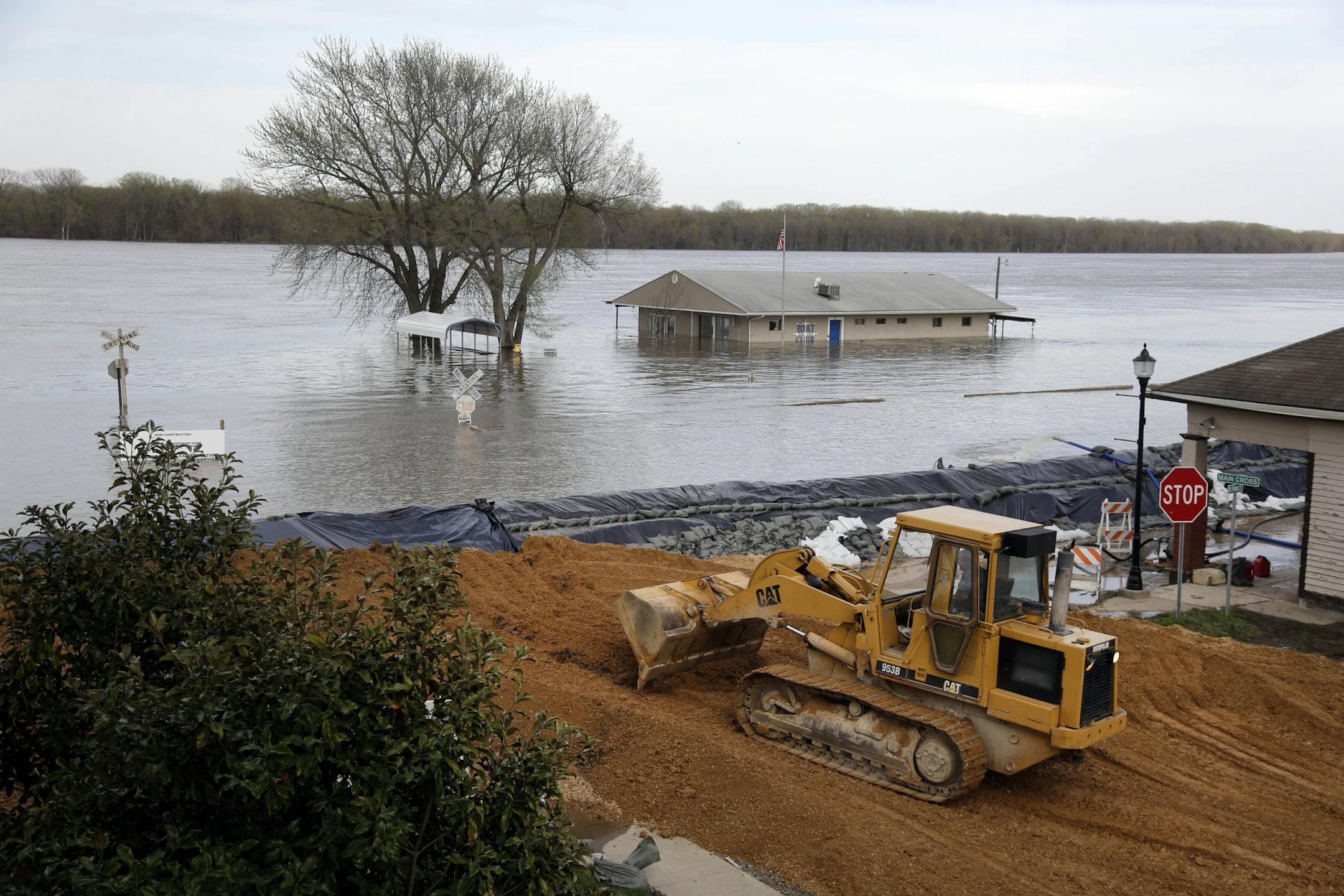 Heavy equipment is used in the effort to reinforce a temporary levee on April 22, 2013, in Clarksville, Mo. The swollen Mississippi River has strained a hastily erected makeshift floodwall in Clarksville, creating two trouble spots that volunteers were scrambling to patch.