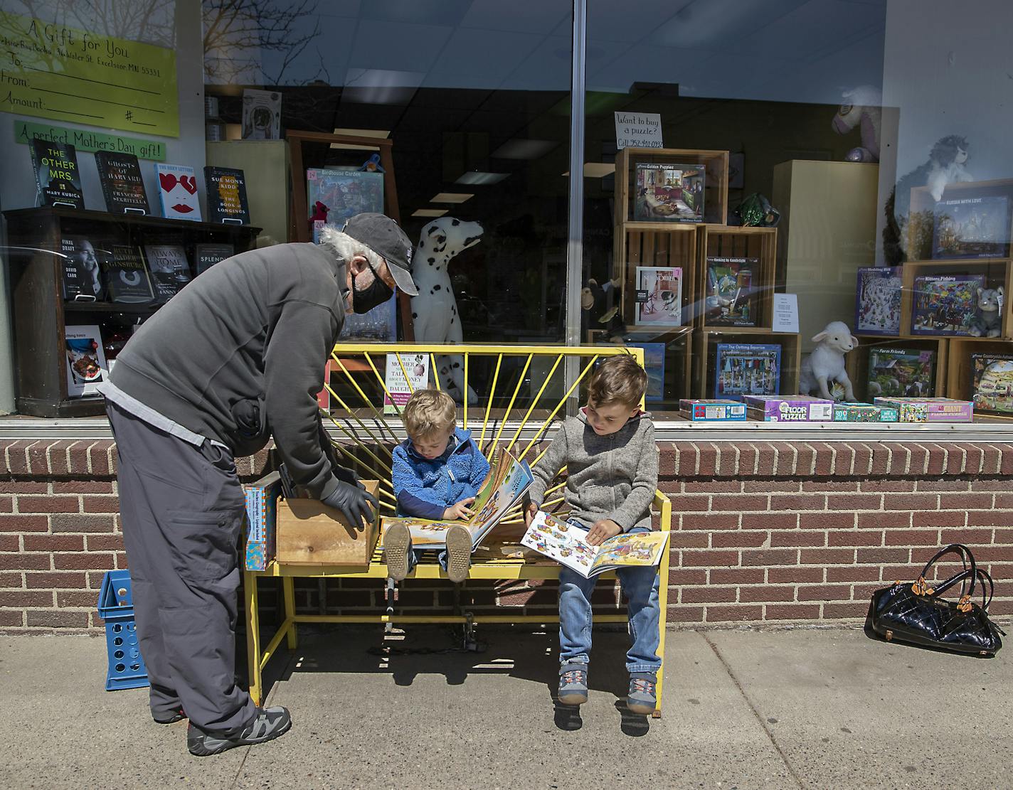 Bill Friedrich looked through books with his grandsons Will, 2, center, and Sully, 5, at Excelsior Bay Books, Monday, May 11, 2020 in Excelsior, MN. When a longtime employee, Ann Woodbeck of Excelsior Bay Books bought the store in January, little did she know a crisis would hit less than three months later, leaving her not knowing how she'd pay the bills. The store raised about $17,000 in a GoFundMe page, but discontinued it early because community support was so strong. Now she has a thriving b