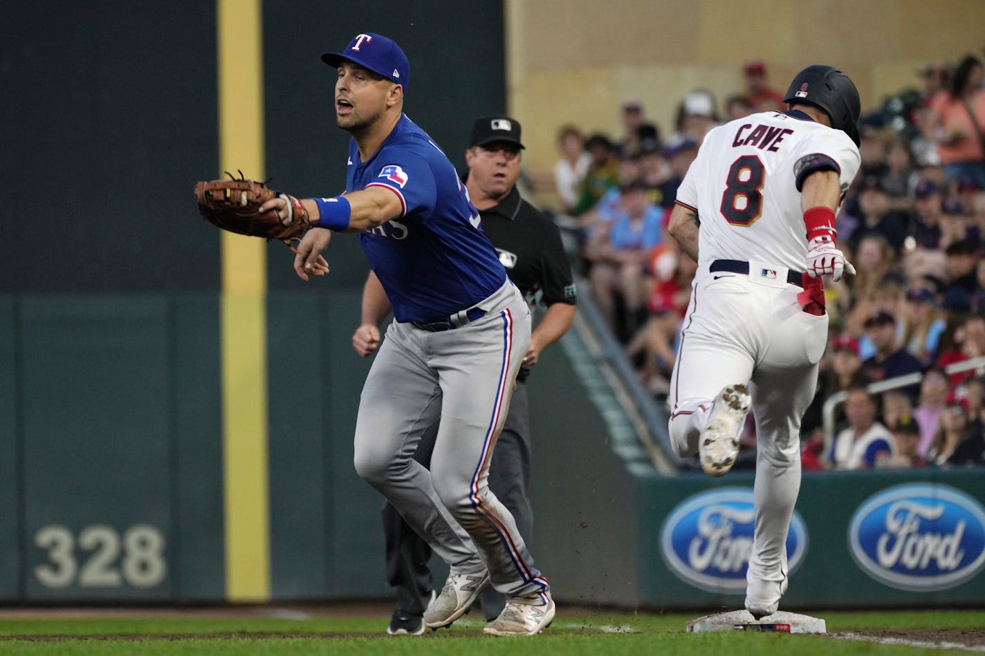 Jake Cave reaches first base safely following a throwing error to Rangers first baseman Nathaniel Lowe in the fifth inning