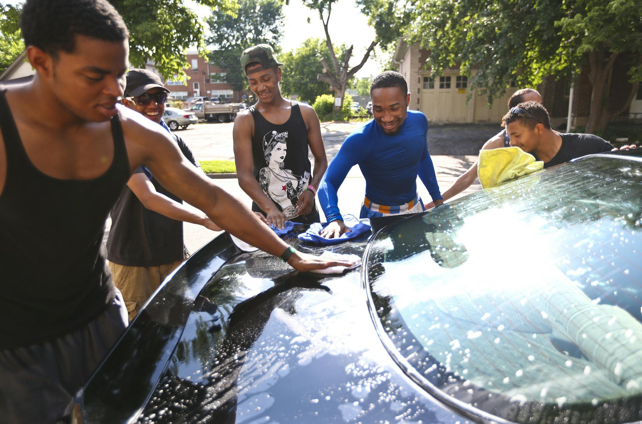 Boxers Michael Barreto and Ve Shawn Owens (in blue) wiped a car clean as they and other boxers from Circle of Discipline gym in South Minneapolis, Minn. did a car wash fundraiser outside their gym during the hot weather on Tuesday, July 16, 2013. ] (RENEE JONES SCHNEIDER * reneejones@startribune.com) I have id of the guy second from left Miguel Gomez but not the two outside guys who disappeared before i got ids
