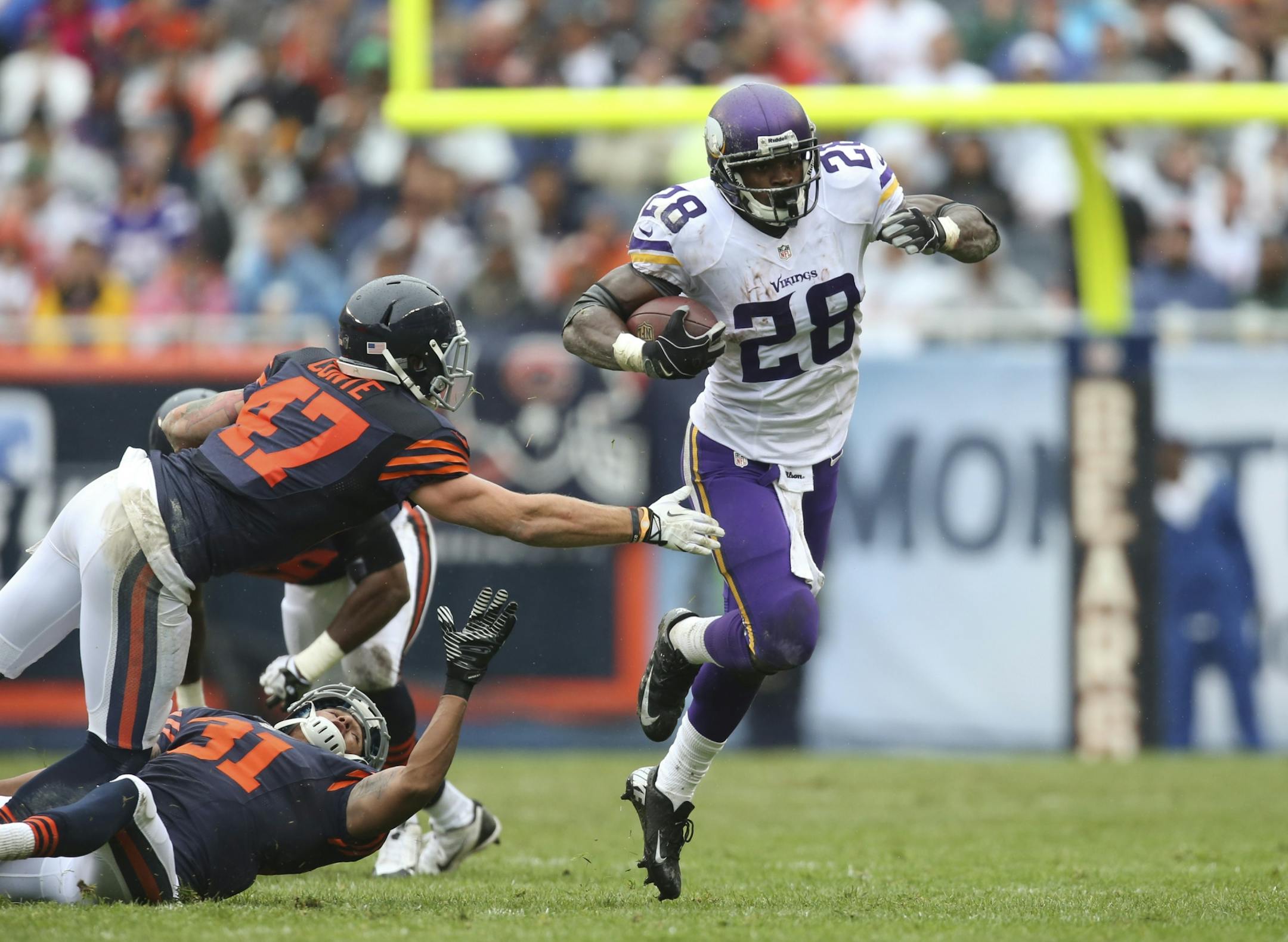 The Minnesota Vikings lost to the Chicago Bears 31-30 at Soldier Field in Chicago on a rainy Sunday afternoon, September 15, 2013. Minnesota Vikings running back Adrian Peterson (28) eluded a the tackle of Chicago Bears free safety Chris Conte (47) while gaining 36 yards on a second quarter run.