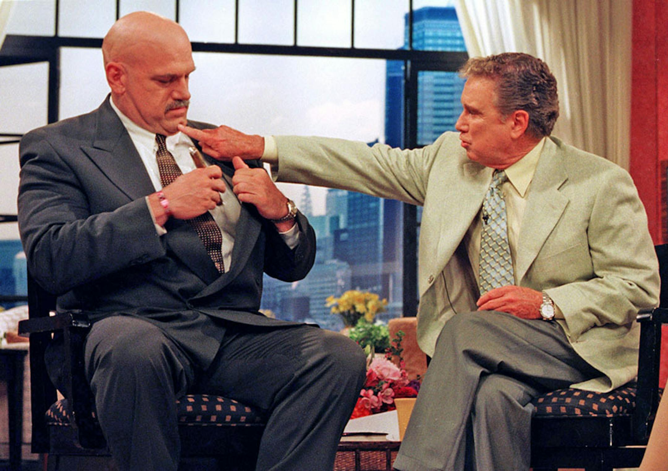 New York, June 3, 1999: Regis sticks a finger in the dimple on Minnesota Governor Jesse VenturaÌs chin after Jesse finished showing off a cigar given him by Arnold Swartzenager.(copy desk help me out, on road, no link liv and no dictionary and I canÌt spell) The Governor appeared on the Regis and Kathie Lee show in New York Wednesday morning on the first day of the east coast leg of his book promotional tour.