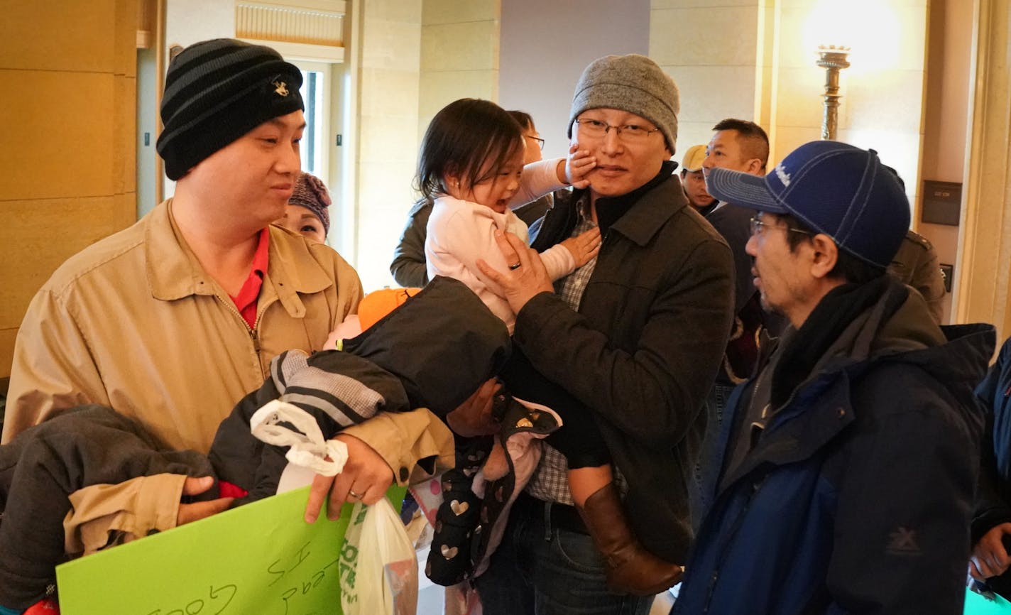 Water Gremlin workers including Leng Vue, left brought his son Leo, 2, to make the point that their company is safe. Workers gathered on the first floor of the Capitol after meeting with Kristin Beckmann, deputy chief of staff to Governor Walz, in the Governor's reception room to ask that the business not be shut down. ] GLEN STUBBE &#x2022; glen.stubbe@startribune.com EDS, the man in the center holding the young girl in pink sweater refused to give his name but stressed that he believes his com