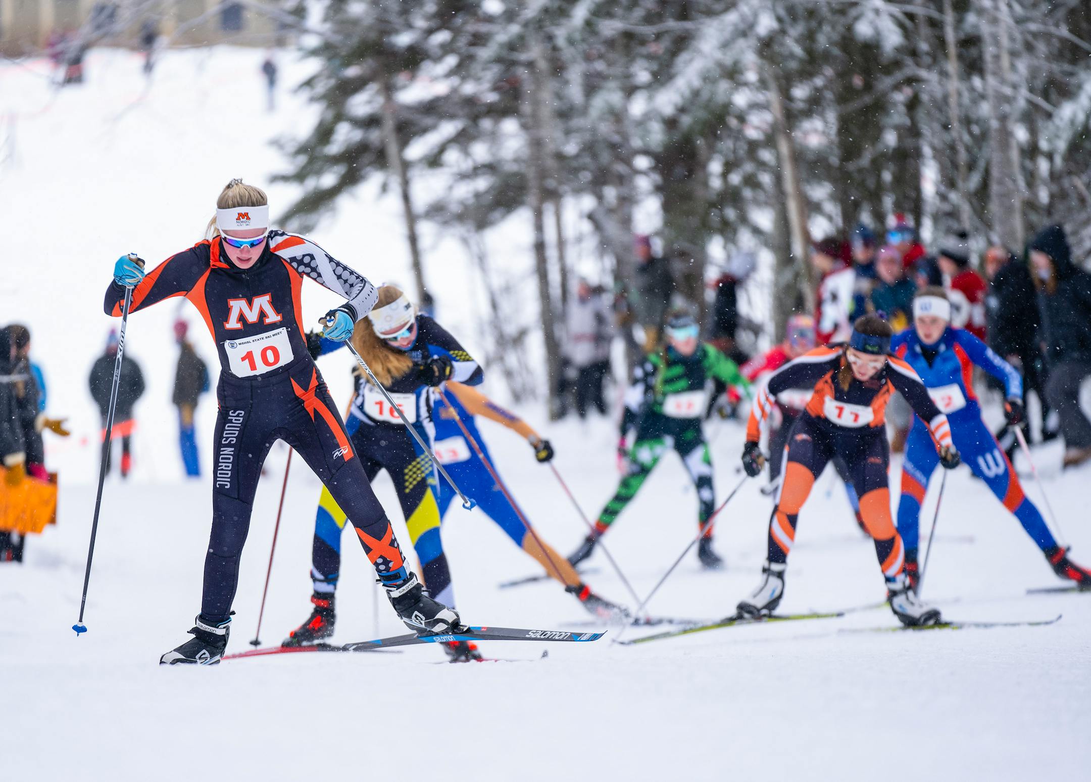 Moorhead nordic skier Abbie Ishaug (19) leads the pack in the first lap of the second heat of the girl's team spring qualification race during the MSHSL Boys and Girls Nordic Ski Racing Meet.
