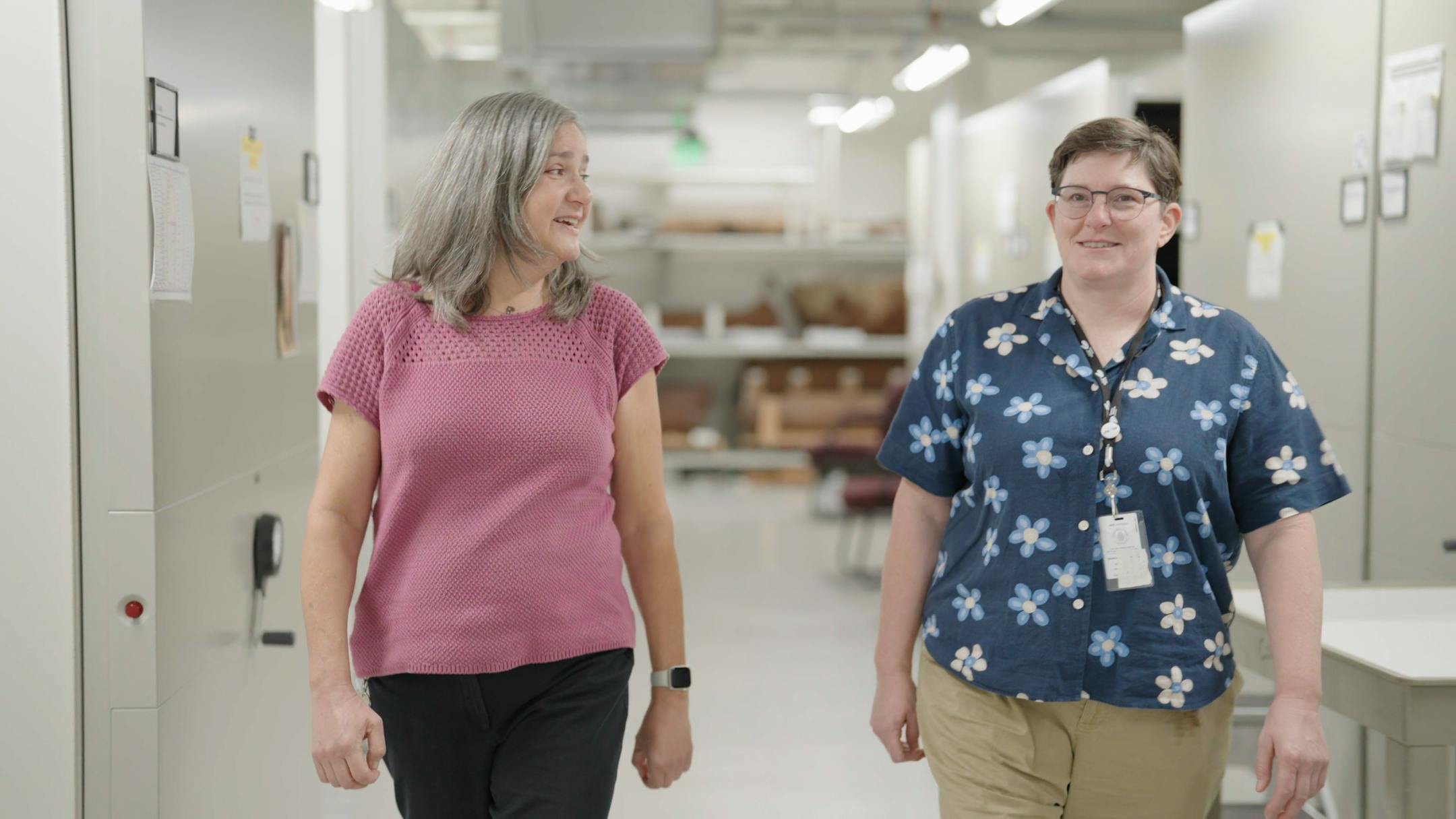 Dr. Laurie Fink, Sr, Director of Research and Collections, and Rebecca Newberry, Director of Collections Stewardship, walk through the vault.