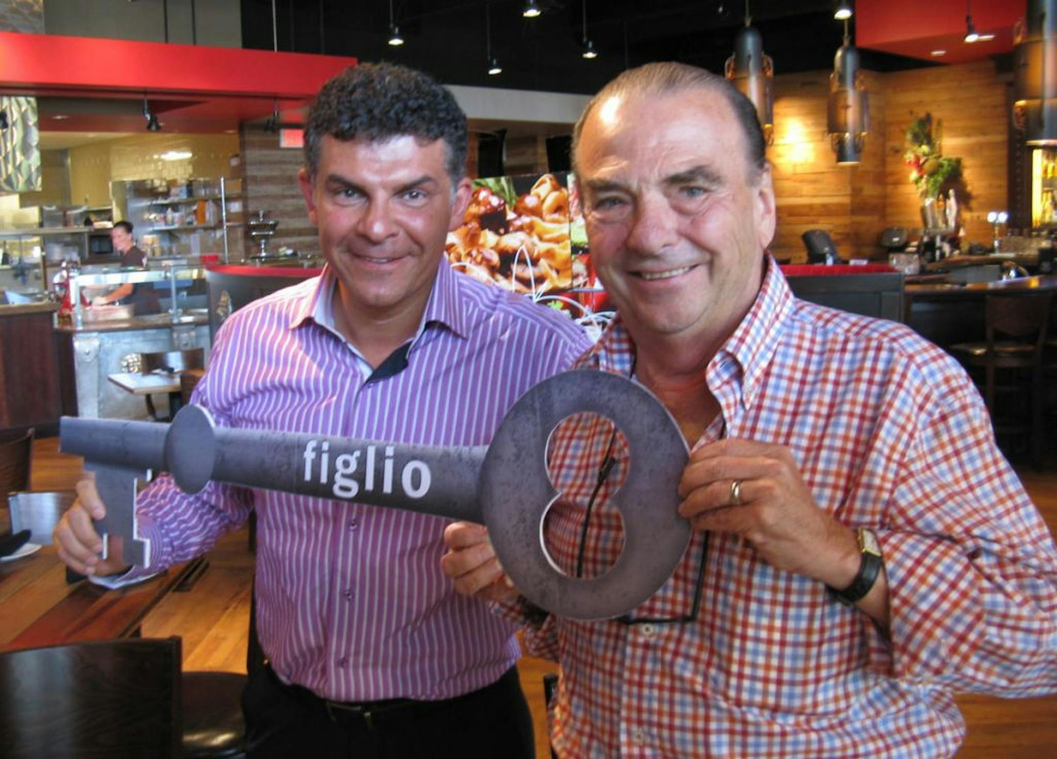 Phil Roberts, right, hands over the key to Figlio to Kam Talebi, left.