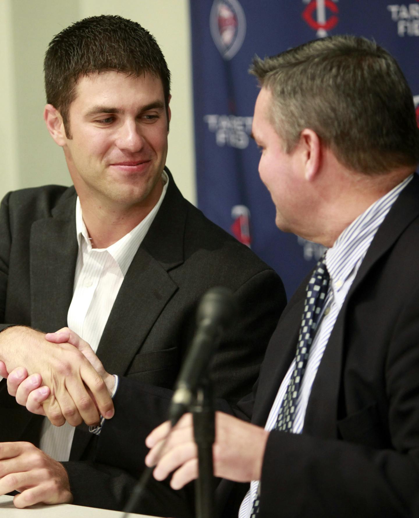 Minnesota Twins catcher Joe Mauer, center, shakes hands with Twins general manager Bill Smith, right, after signing a contract as Mauer's agent Ron Shapiro, left, looks on during a news conference at the team's training facility in Fort Myers, Fla., Monday, March 22, 2010. Mauer agreed to an eight-year, $184 million contract extension to stay with the Twins. (AP Photo/Steven Senne) ORG XMIT: MIN2014022419592350