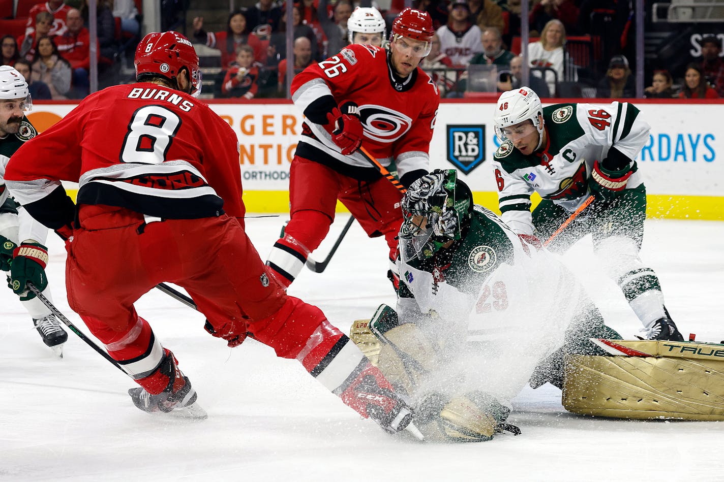 Carolina Hurricanes' Brent Burns (8) slips the puck past Minnesota Wild goaltender Marc-Andre Fleury (29) for a goal with Hurricanes' Paul Stastny (26) and Wild's Jared Spurgeon (46) nearby during the second period of an NHL hockey game in Raleigh, N.C., Thursday, Jan. 19, 2023. (AP Photo/Karl B DeBlaker)