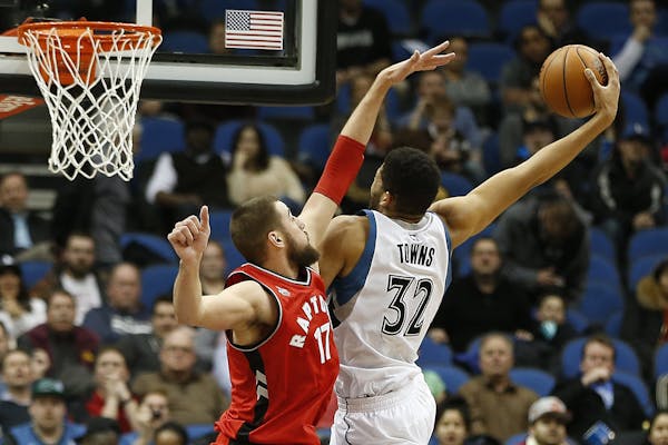 Timberwolves center Karl-Anthony Towns stretched out to shoot the ball against Raptors center Jonas Valanciunas in the second half Wednesday of the Wo
