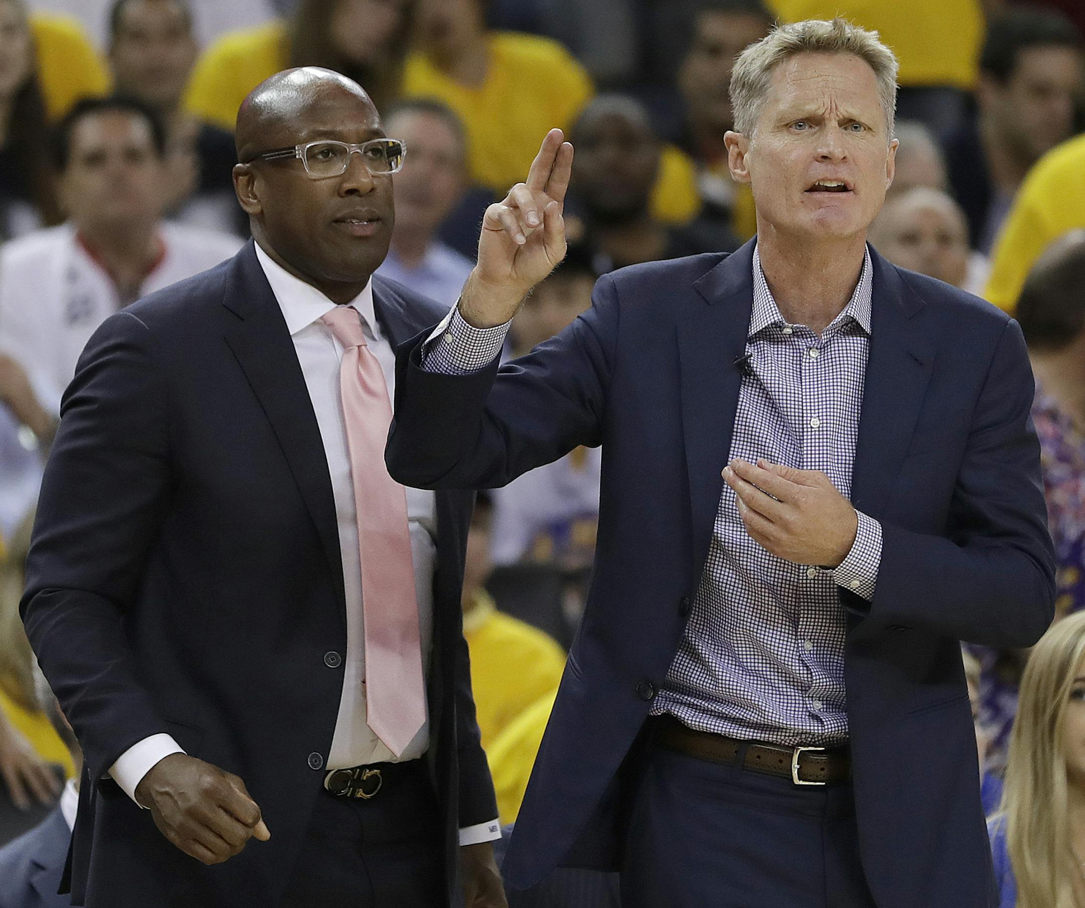 Golden State Warriors head coach Steve Kerr, right, gestures next to interim head coach Mike Brown during the first half of Game 2 of basketball's NBA Finals against the Cleveland Cavaliers in Oakland, Calif., Sunday, June 4, 2017. (AP Photo/Marcio Jose Sanchez)