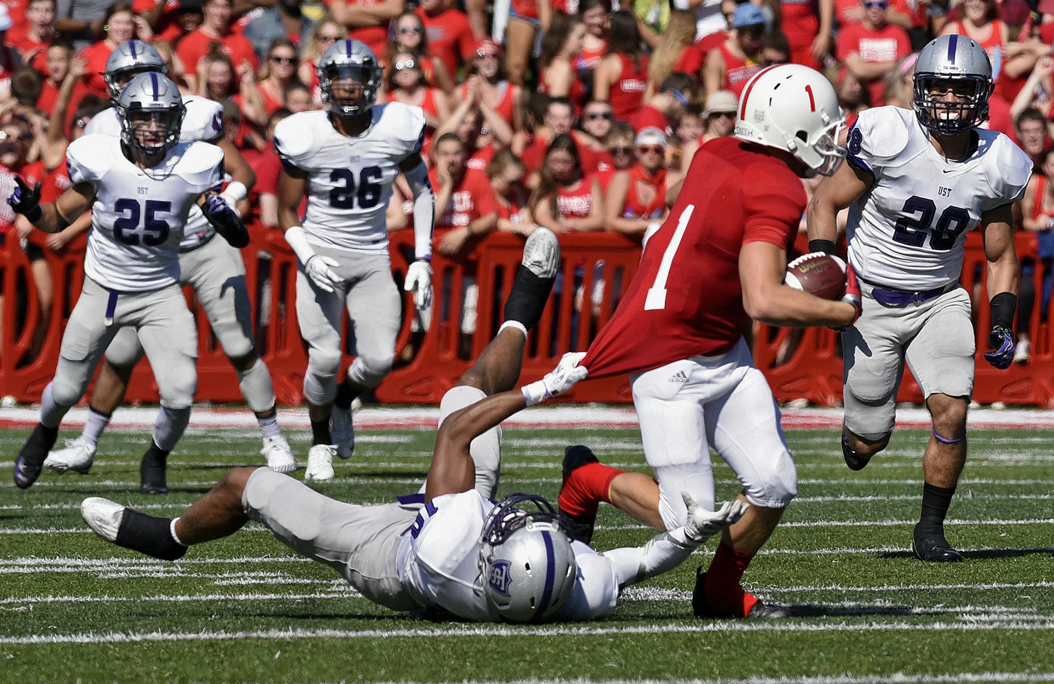 St. Thomas' Mozus Ikuenobe brings down St. John's Josh Bungum during a college football game Saturday, Sept. 26, 2015, in Collegeville, Minn. The Tommies won 35-14, giving St. John's its only loss of the season.