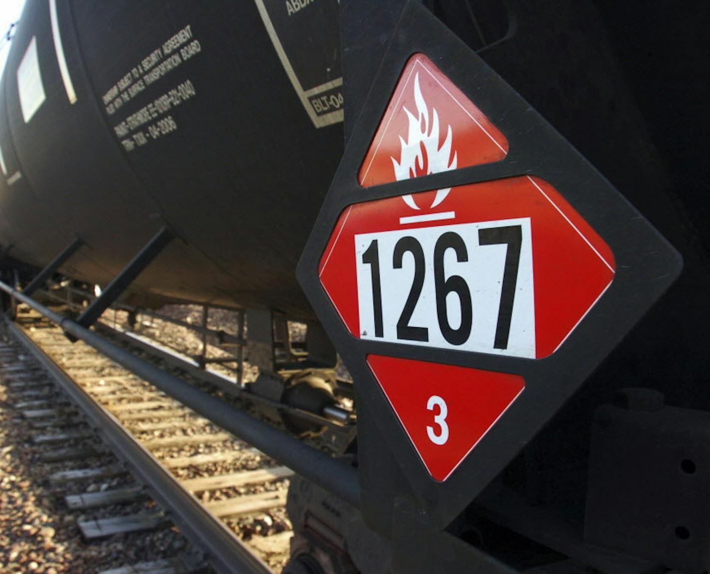 FILE - This Nov. 6, 2013 file photo shows a warning placard on a tank car carrying crude oil near a loading terminal in Trenton, N.D. In new rules that went into effect Wednesday, April 1, 2015, North Dakota is requiring oil companies to reduce the volatility of crude before it's loaded onto rail cars. Crude from North Dakota's oil patch has been linked to several fiery oil train crashes in the past two years. (AP Photo/Matthew Brown, File)