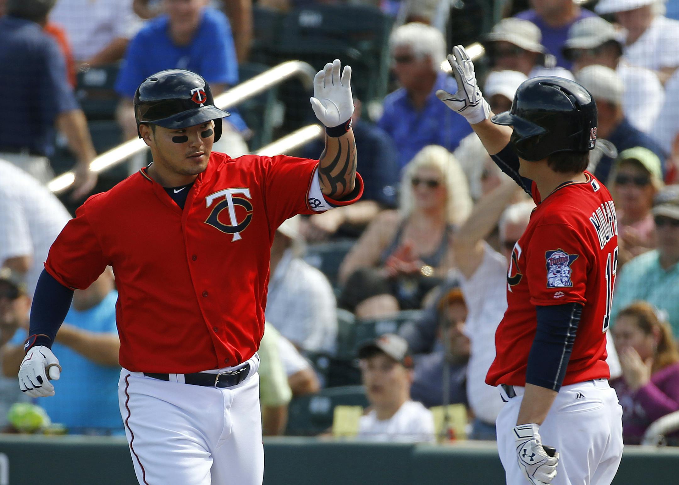 Minnesota Twins' Byung Ho Park, left, of South Korea, high-fives teammate John Ryan Murphy after hitting a solo home run in the fourth inning of a spring training interleague baseball game against the Miami Marlins in Fort Myers, Fla., Friday, March 11, 2016. (AP Photo/Patrick Semansky)