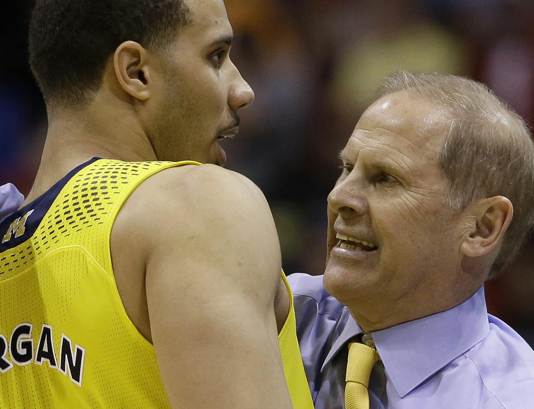 Michigan head coach John Beilein celebrates with Jordan Morgan (52) after an NCAA Midwest Regional semifinal college basketball tournament game against the Tennessee Friday, March 28, 2014, in Indianapolis. Michigan won 73-71.(AP Photo/David J. Phillip)