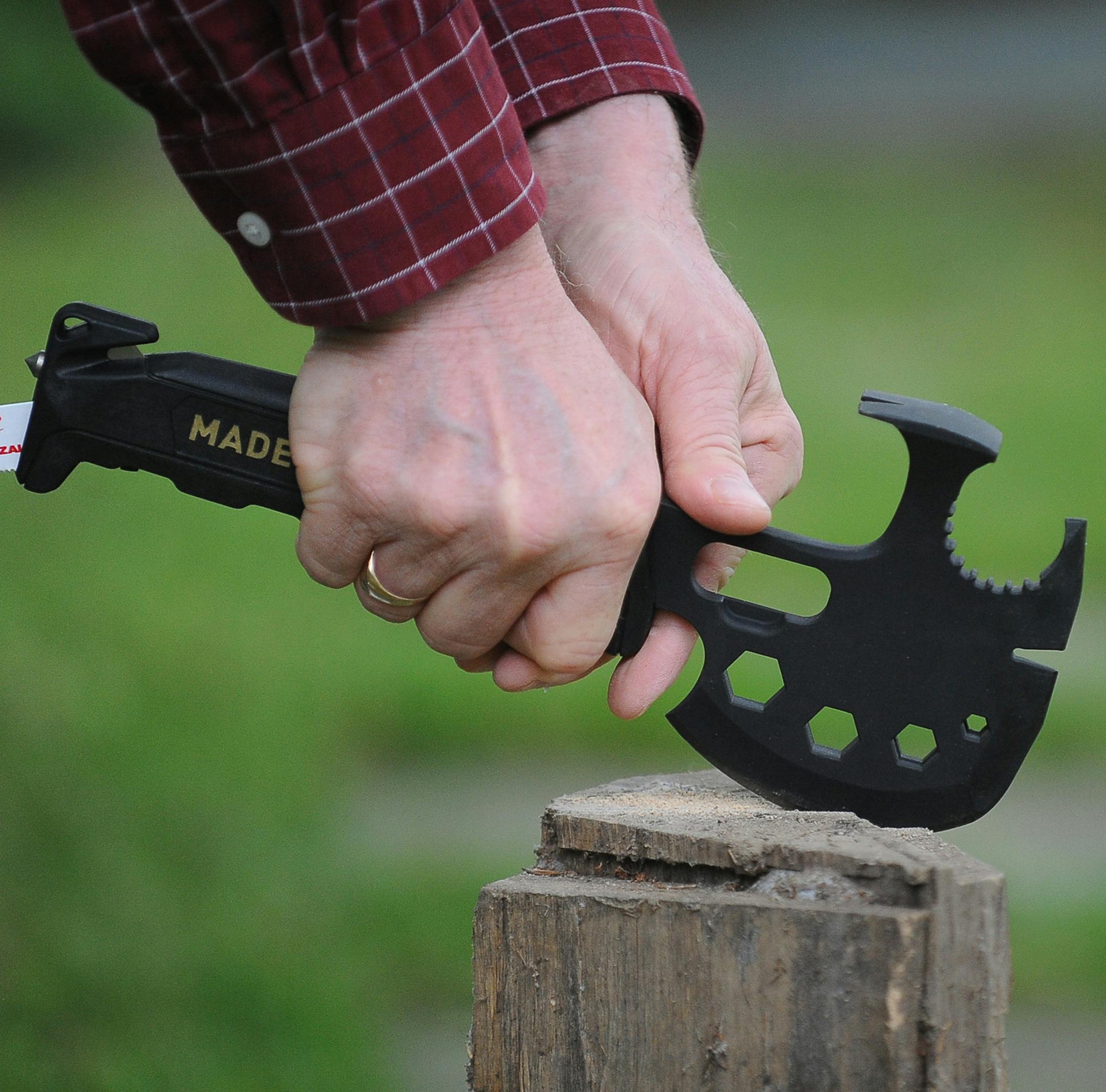 Marvin Weinberger demonstrates his tool, the Off-Grid Survival Axe, by cutting a block of firewood at his home office on June 7, 2017 in Havertown, Pa. (Cameron B. Pollack/Philadelphia Inquirer/TNS)
