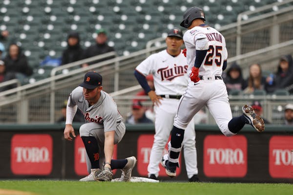 Detroit Tigers first baseman Spencer Torkelson, left, takes the throw from third baseman Jeimer Candelario to put out to Minnesota Twins' Byron Buxton