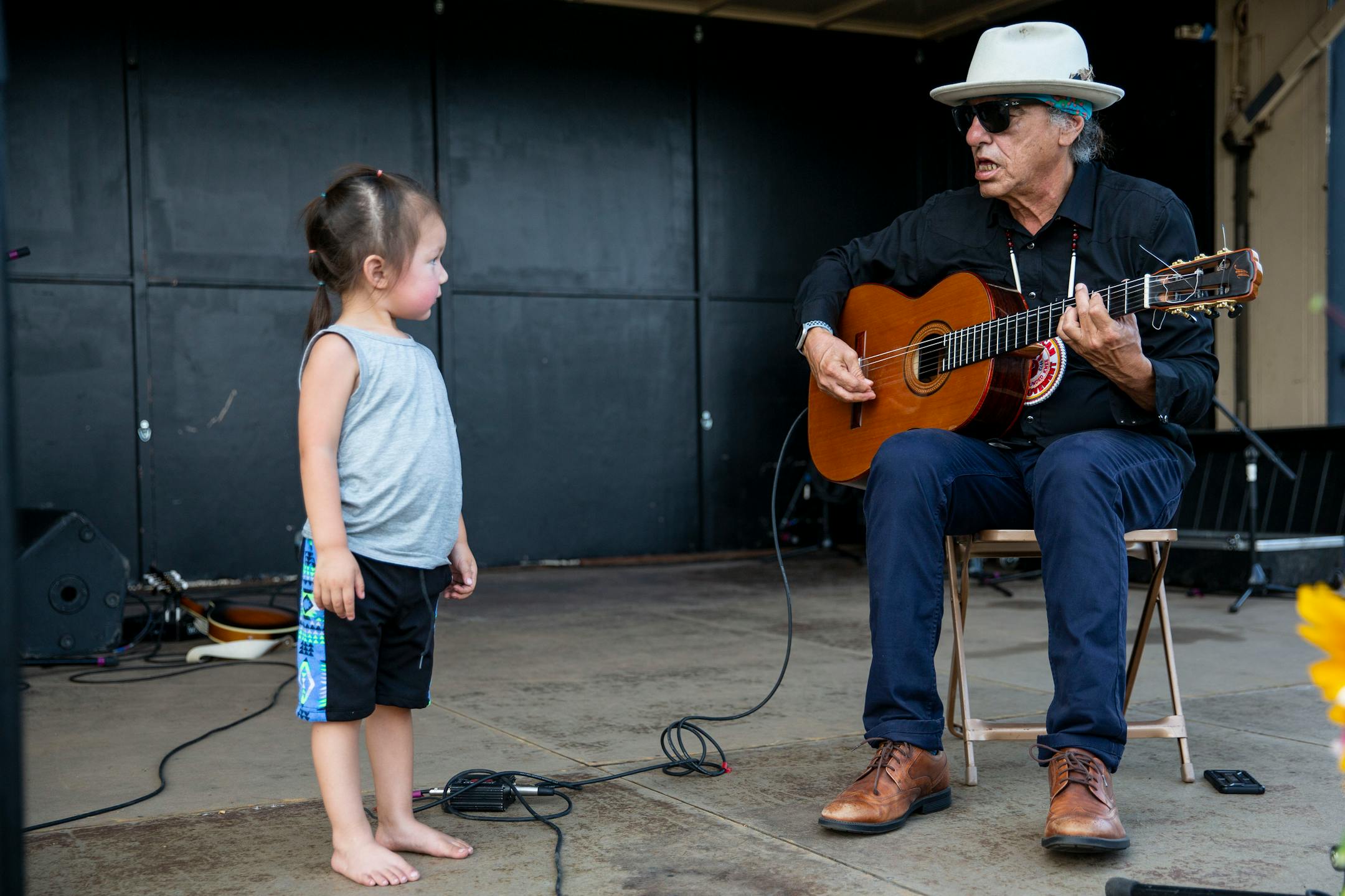 Keith Secola, an indigenous performer from Cook, Minn., did a mic check while Hvrvnwvce, the son of Samsoche Sampson who performed with Secola, watched on the side stage at the Water is Life Festival on Wednesday.