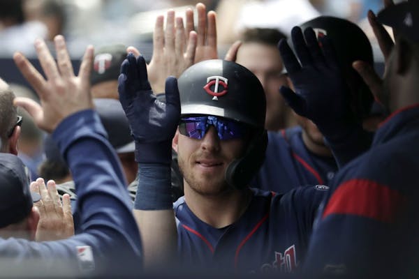 The Twins' Mitch Garver is greeted by teammates in the dugout after hitting a two-run home run off Yankees pitcher J.A. Happ on Saturday in New York.