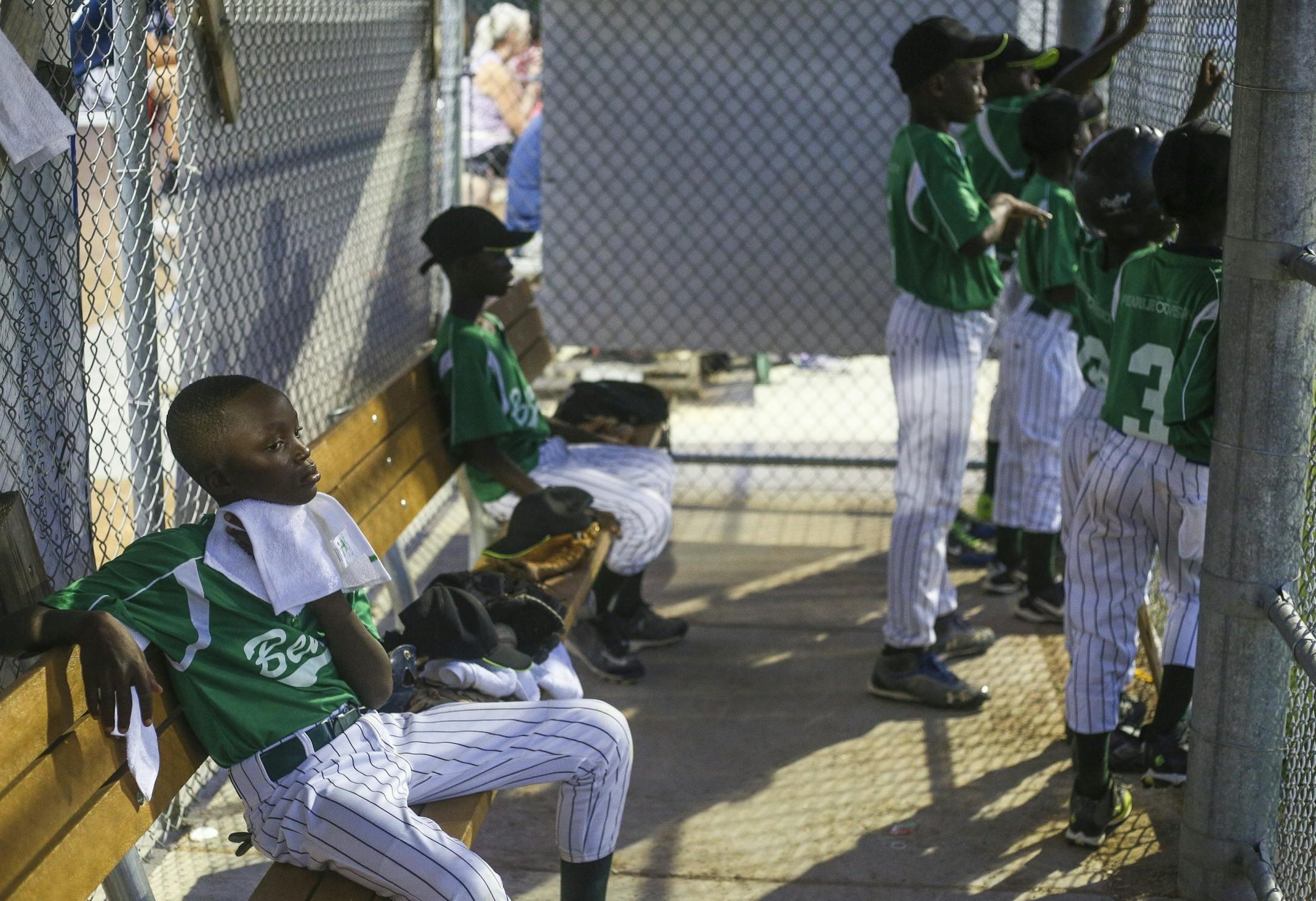 Thomas Agbo, bottom left, dries off his face after pitching in their scrimmage against the Robbinsdale 10-year-old all-star team at Lakeview Terrace Park on Tuesday, August 2, 2016 in Robbinsdale.