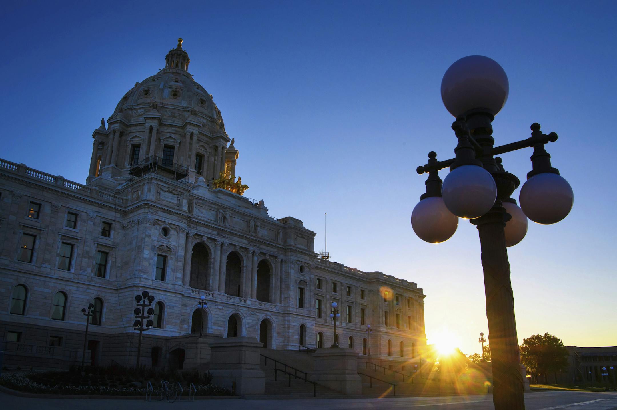 FILE - In this May 24, 2017, file photo, sun rises behind the Minnesota State Capitol in St. Paul, Minn. Minnesota lawmakers return to Capitol on Tuesday, Feb. 20, 2018, with a long list of work, and not much time to tackle it. The Legislature will discuss big-time tax code revisions, opioid abuse prevention efforts and possible constitutional amendments on the November ballot. (Glen Stubbe/Star Tribune via AP, File)