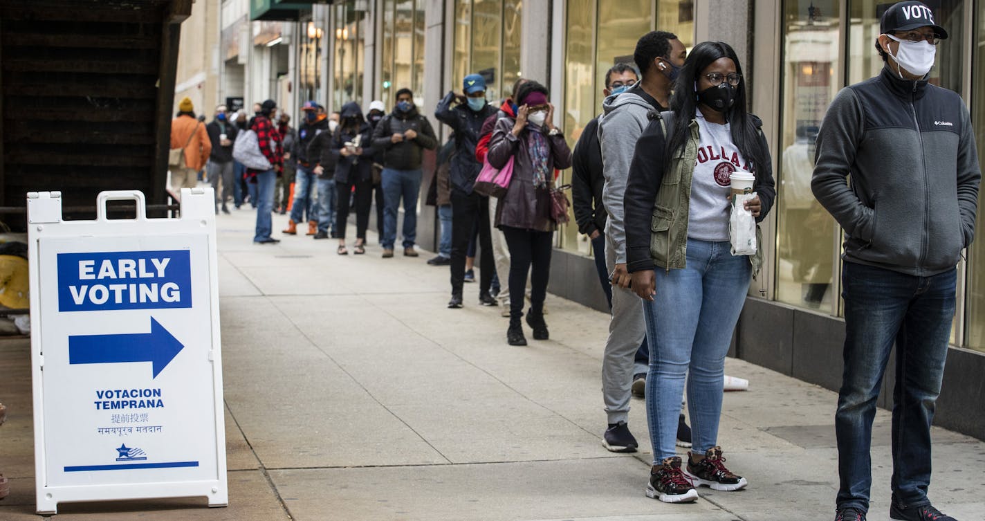 Hundreds of people wait in line to early vote at the Loop Super Site, Thursday morning, Oct. 1, 2020, in Chicago. Voters on Thursday say they understand the fears of contracting the deadly coronavirus has prompted millions of Americans to vote by mail. But they are worried about the "chaos and confusion" that President Donald Trump has created about mail-in voting and they say they want to vote in person to make sure those votes are counted. (Ashlee Rezin Garcia/Chicago Sun-Times via AP)