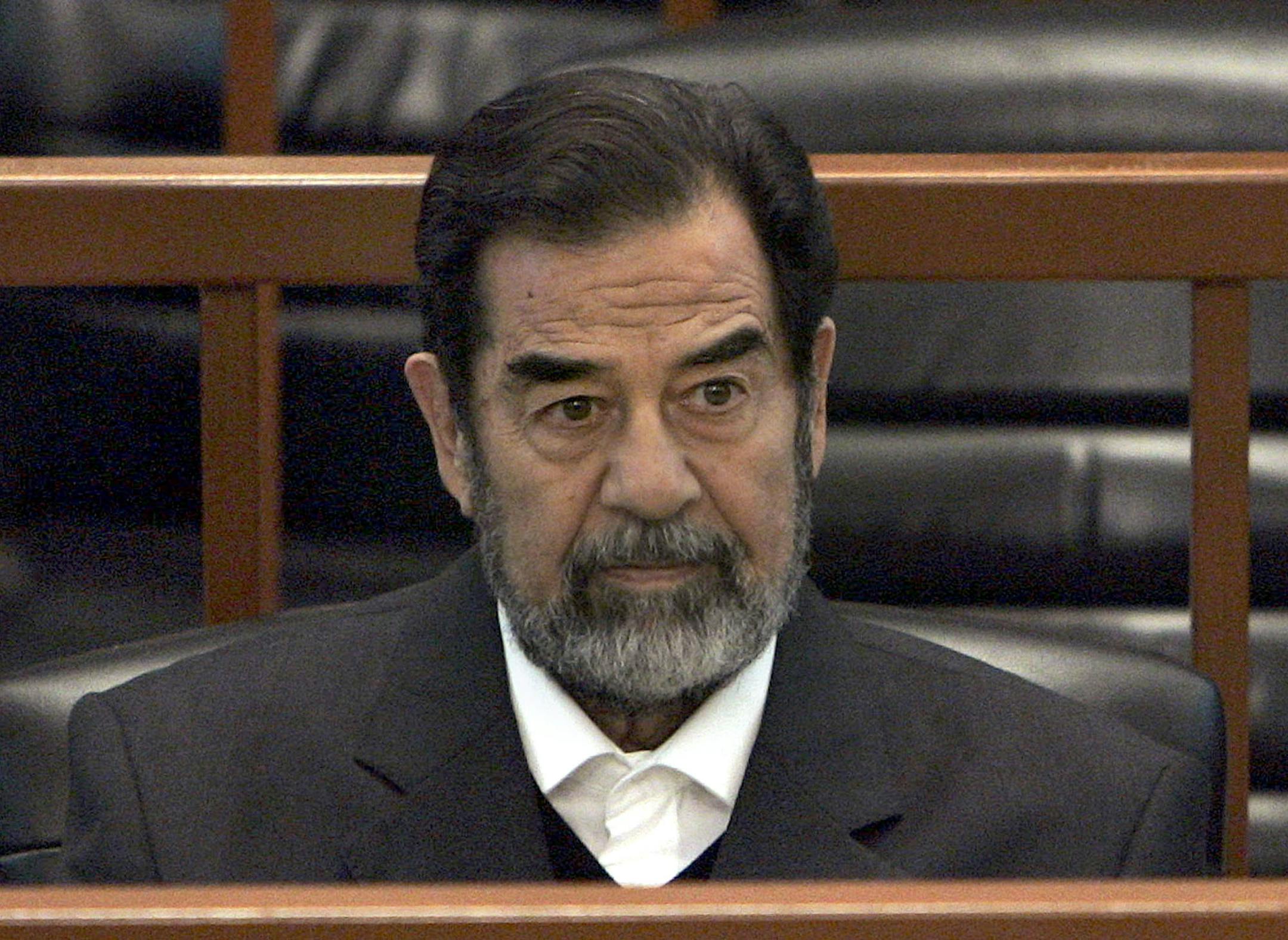 FILE - In this Dec. 6, 2006 file photo, former Iraq leader Saddam Hussein sits in court in Baghdad, Iraq, during the "Anfal" trial against him. Republican Donald Trump is again praising the former Iraqi President Hussein's ruthlessness, saying he killed terrorists "so good." Trump was speaking at a rally Tuesday, July 5, 2016, in North Carolina when he turned to the former Iraqi leader. (AP Photo/Chris Hondros, Pool, File)