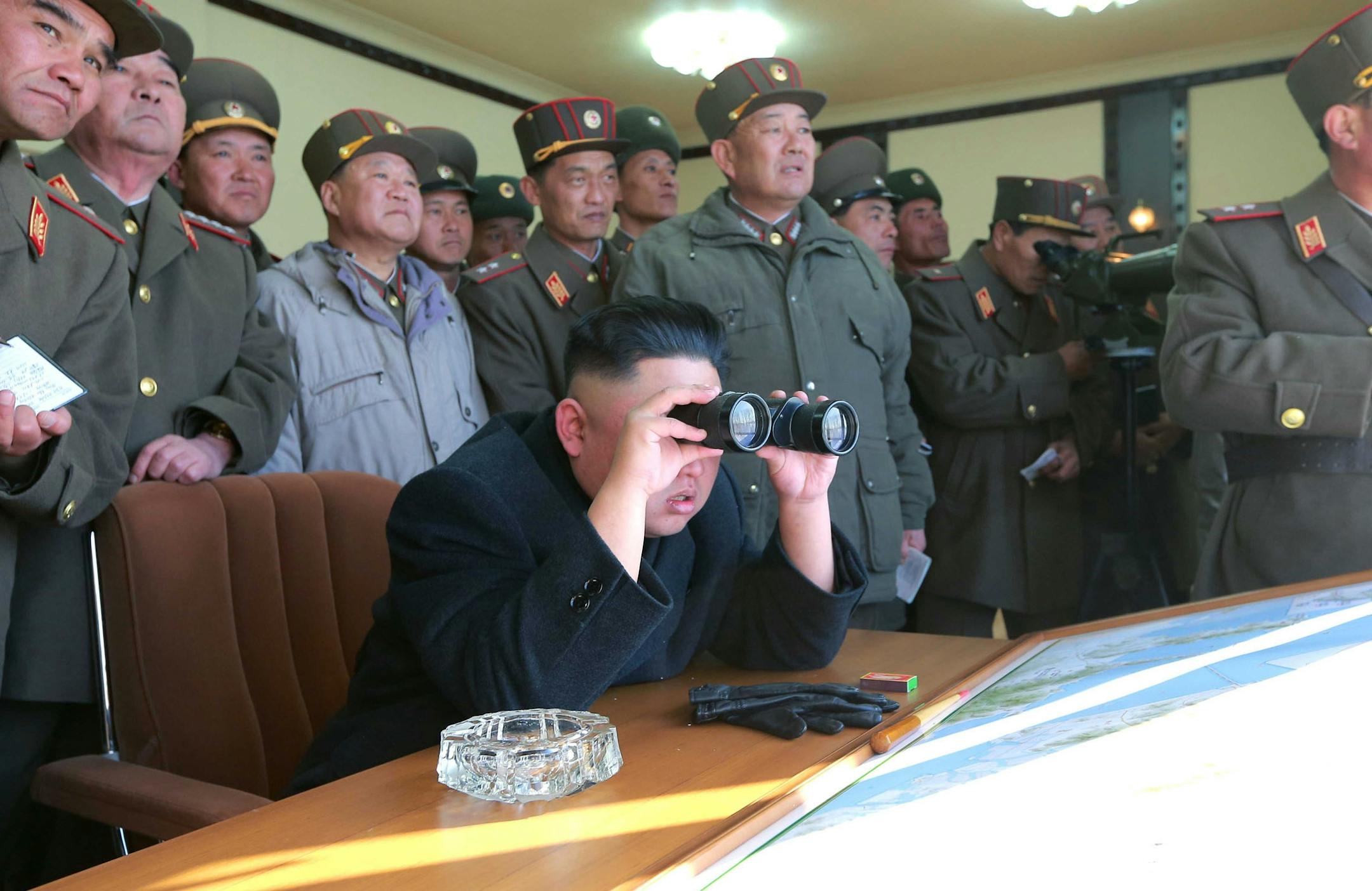 In this undated photo released by the Korean Central News Agency (KCNA) and distributed Thursday, March 14, 2013 by the Korea News Service, North Korean leader Kim Jong Un uses a pair of binoculars to watch live ammunition firing drills by the Jangjae Islet Defense Detachment and the Mu Islet Hero Defense Detachment deployed in the southwestern sector in North Korea. (AP Photo/KCNA via KNS) JAPAN OUT UNTIL 14 DAYS AFTER THE DAY OF TRANSMISSION