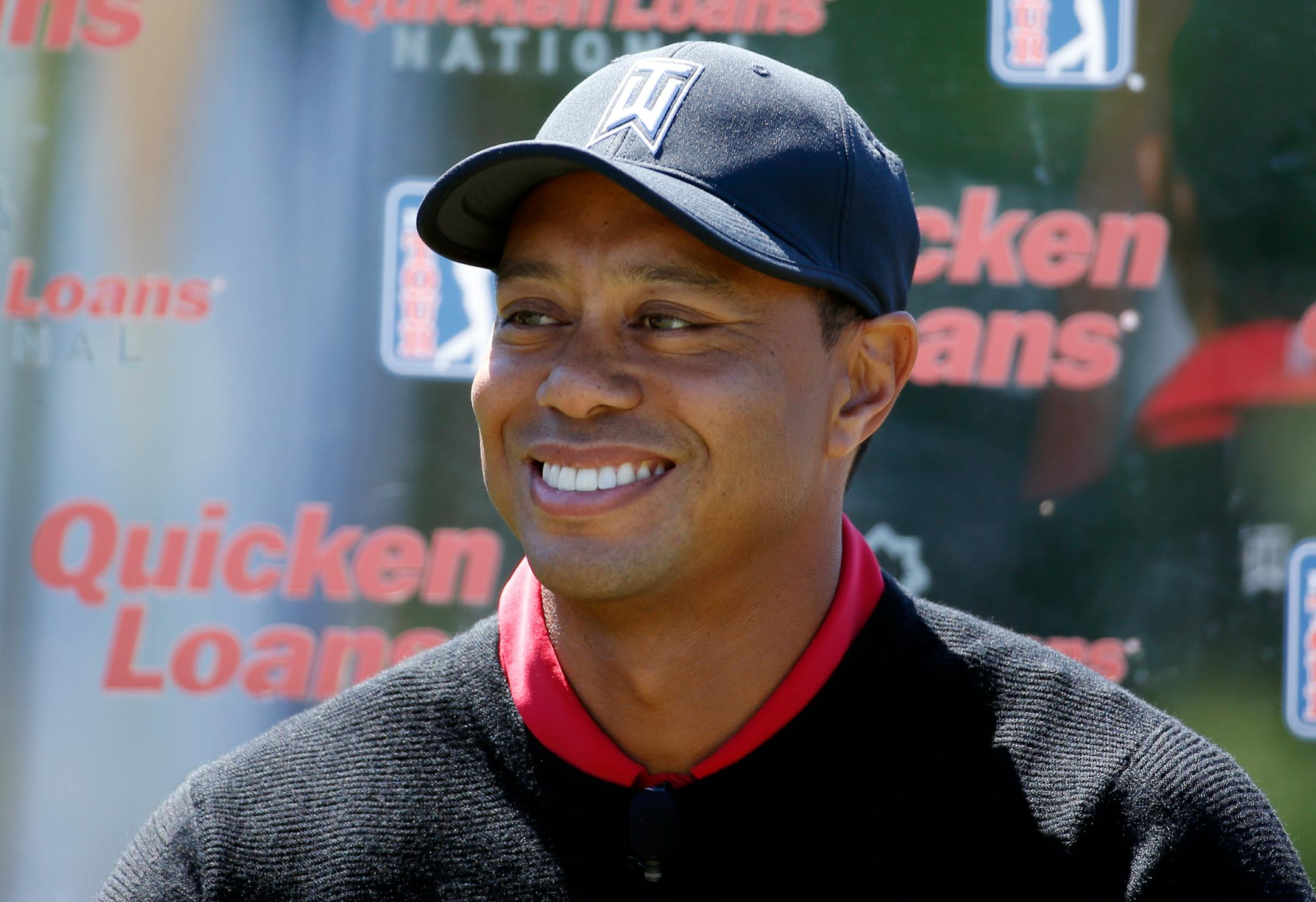 FILE - In this May 16, 2016, file photo, Tiger Woods pauses during a Quicken Loans National golf tournament media availability on the 10th tee at Congressional Country Club, in Bethesda, Md. Tiger Woods' absence from golf isn't just being felt on the course. The Quicken Loans National, which he usually hosts but will be without him this year as he's being treated at a clinic for his use of prescription drugs, is doing its best to press on without him, but the buzz around the event has faded. (AP