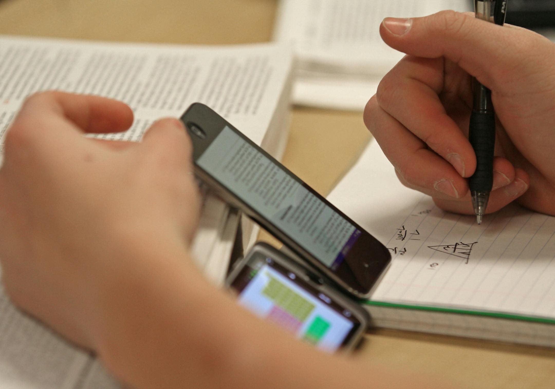 (center) A Lakeville South High School student used an Iphone to access a virtual textbook during Jason Just's AP chemistry class at the school on 1/31/12. The students were using netbooks, smart phones, laptops and tablets to access the class materials. Lakeville is looking to become one of the most high tech districts in the state. It will start by making all of its schools wireless by April and include giving handheld devices or laptops to every kid and teacher in grades 3-12. Among the pione