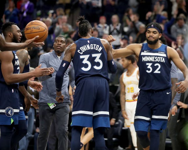 The Minnesota Timberwolves Josh Okogie, left to right, Robert Covington (33) and Karl-Anthony Towns (32) celebrate their 125-119 overtime win against 