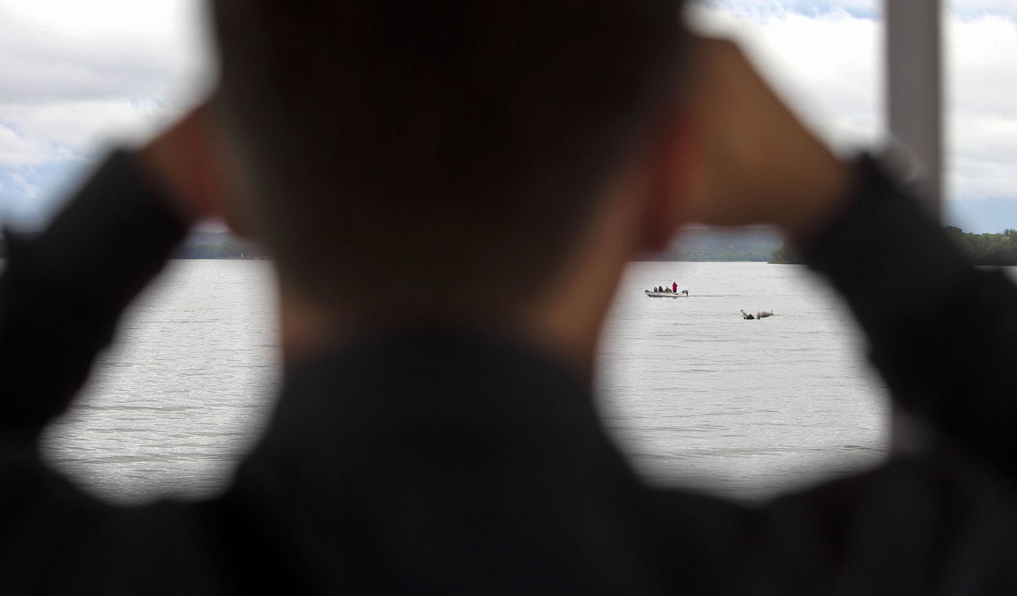 Author Chad Lewis of Wisconsin, who has written a book about the legend of Pepie and is also an adventurer and lecturer and travels the world trying to prove lore, scans the waters with a binocular Saturday, June 8, 2014, on Lake Pepin in Lake City, MN.] (DAVIDJOLES/STARTRIBUNE) djoles@startribune.com Lake Pepin has a sea creature. Or had. Or has had several. From, the time of Father Hennepin until last year, "something" has been sighted, or sensed, or imagined. There's a $50,000 reward - yet un