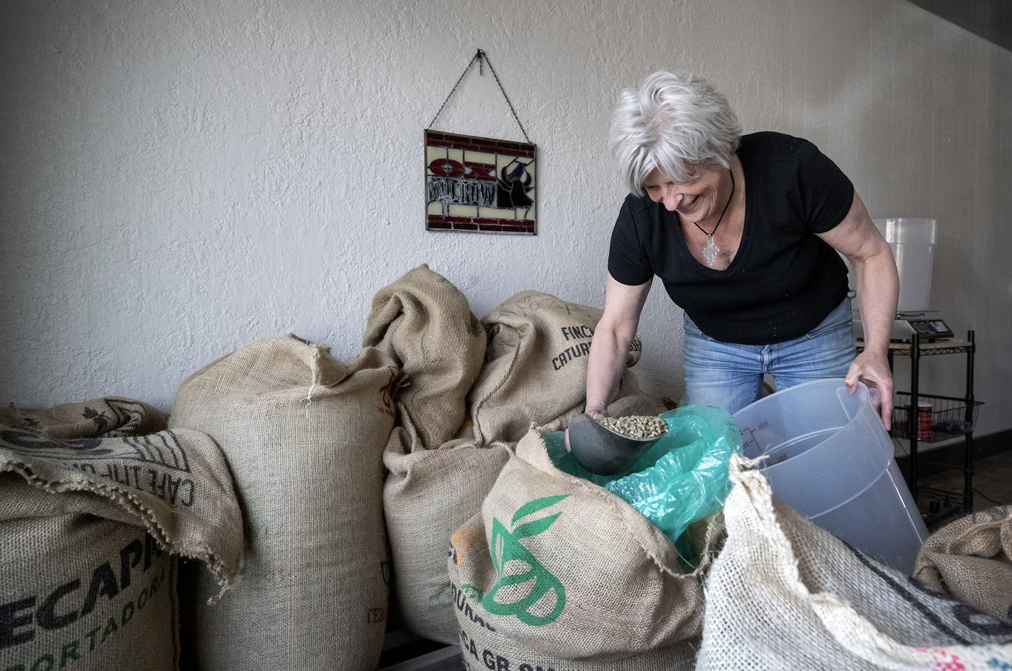 Mara Crombie owner of Ox and Crow demonstrated scooping beans from bags for roasting. ] CARLOS GONZALEZ &#x2022; cgonzalez@startribune.com &#x2013; Lake Elmo, MN &#x2013; May 7, 2020, Ox and Crow Roastery, Two Lake Elmo coffee businesses are teaming up during the pandemic to stay open.