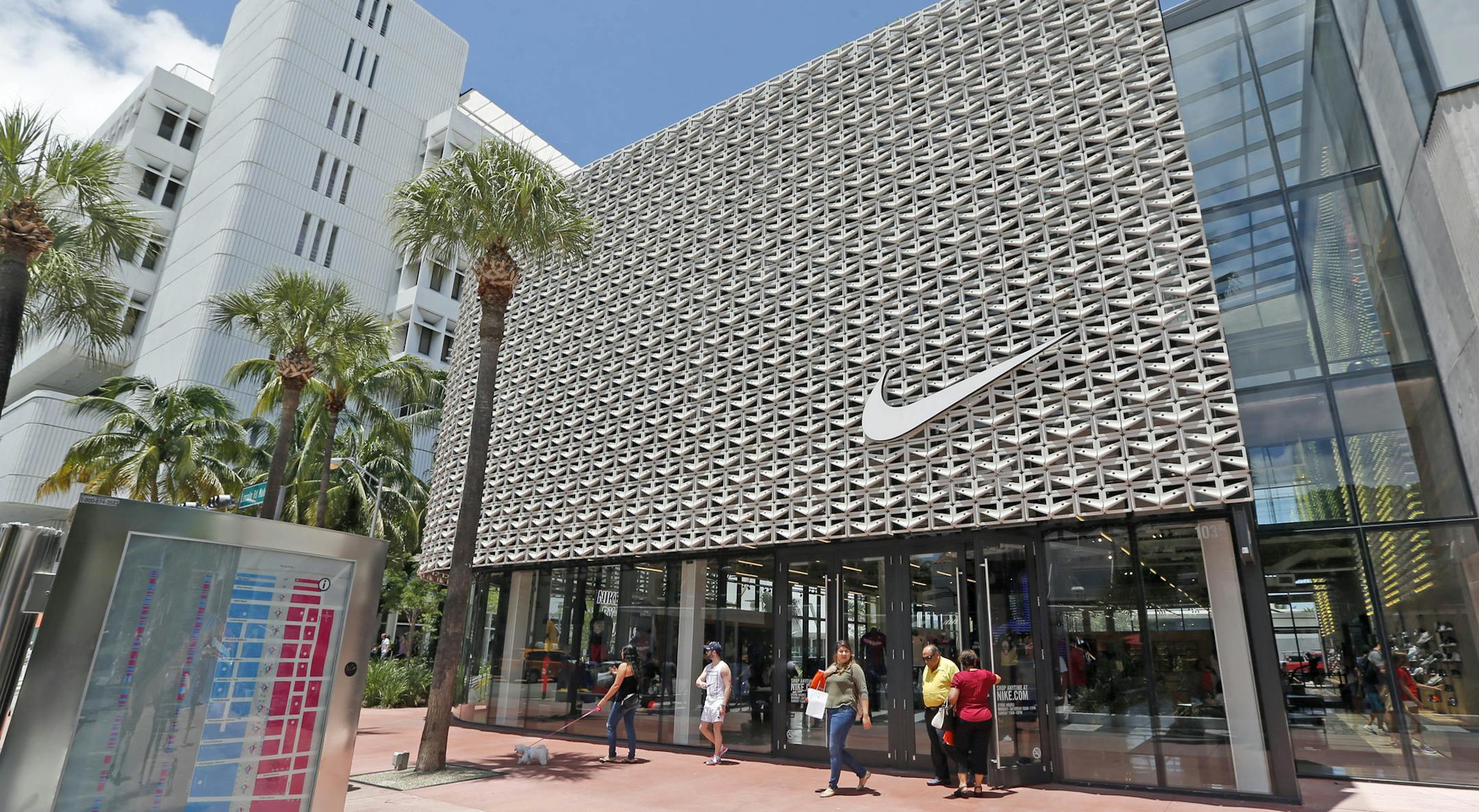In this Tuesday, Aug. 8, 2017, photo, shoppers walk out of a Nike store in Miami Beach, Fla. Nike Inc. reports earnings, Tuesday, Sept. 26, 2017. (AP Photo/Alan Diaz)