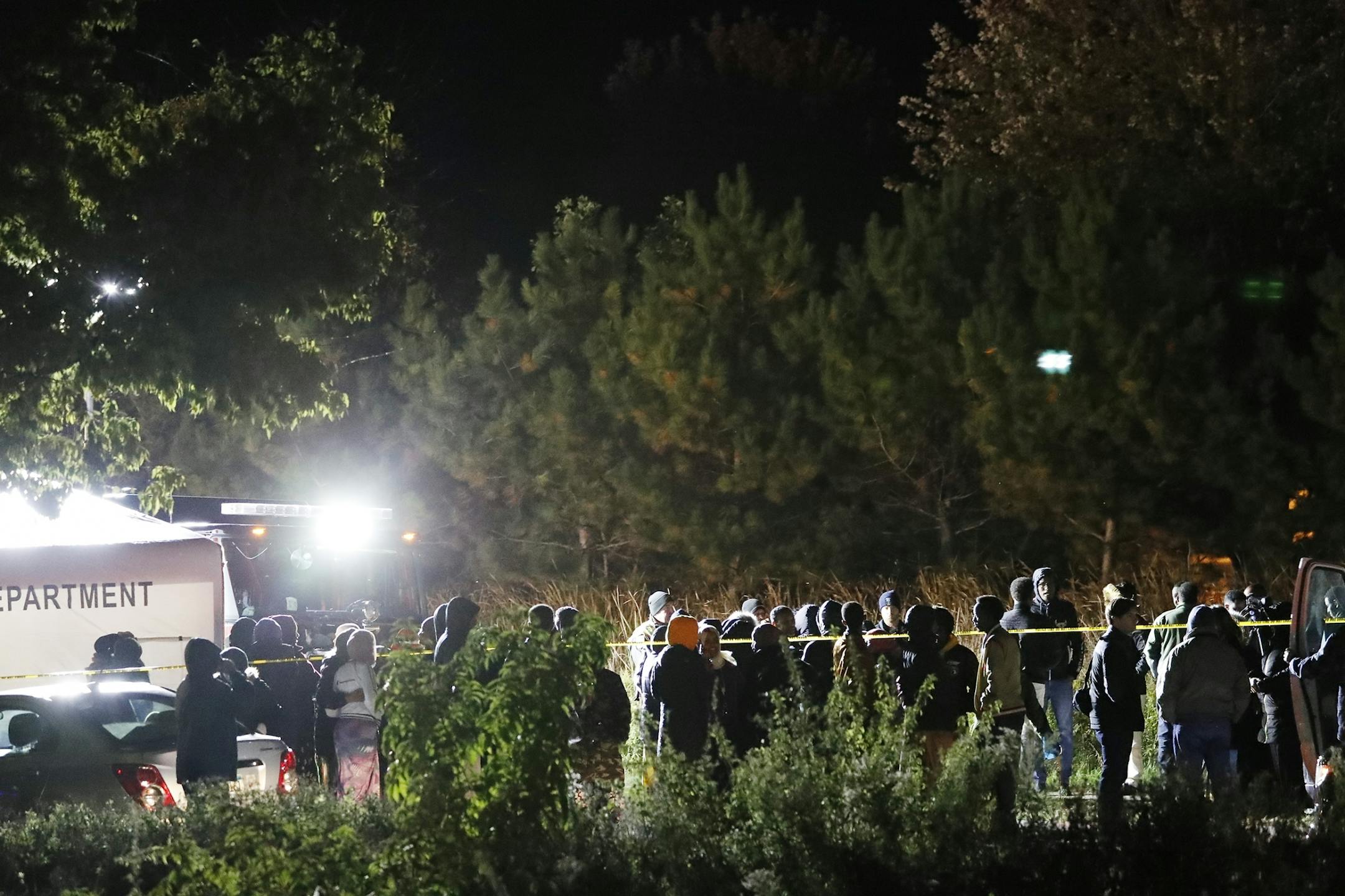 Members of the Somali community gather at the scene.