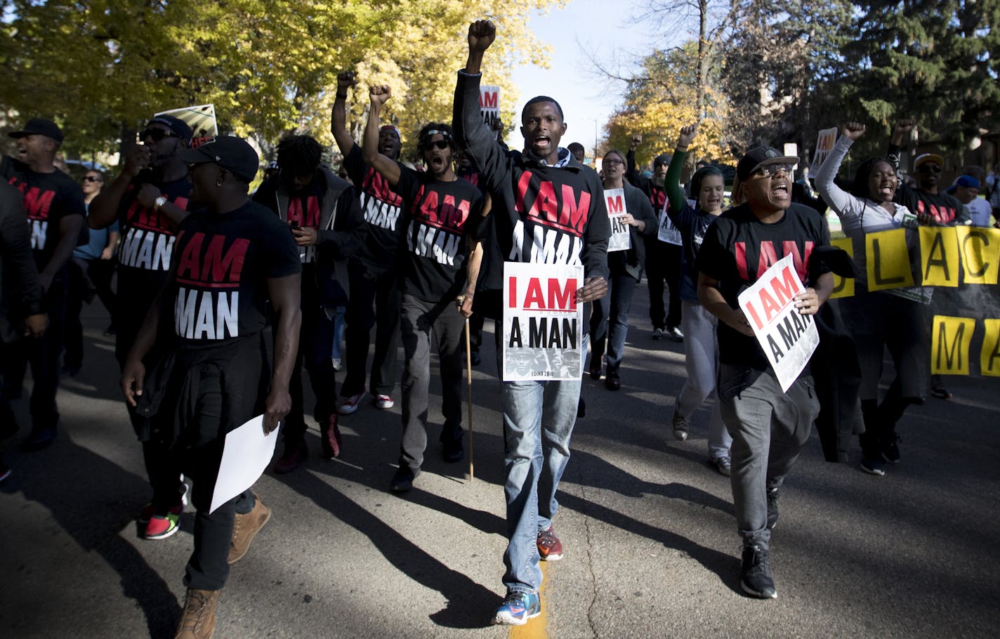 Hashim Yonis, center, raised his fist alongside others protesting the issues of racial profiling and police violence against black men.