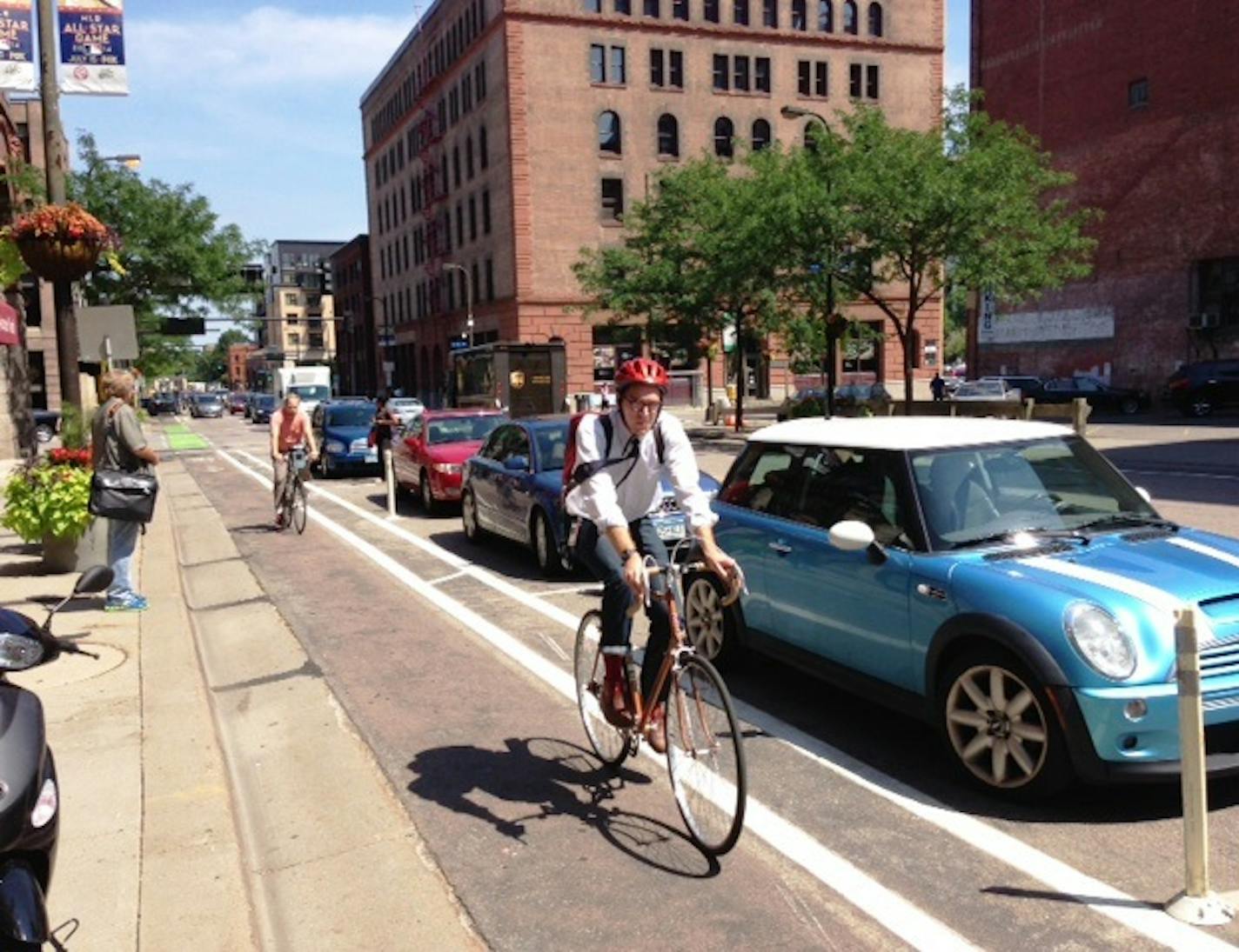 Bikers use a protected bike lane on 1st Avenue N. that's between the curb and parked cars.