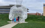 Visitors to PappaJohn Sculpture Park take a closer look at "Nomade," a sculpture by Jaume Plensa. (/TNS) ORG XMIT: 38937388W