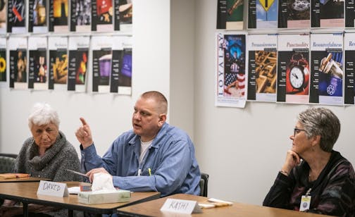 Inmate David Brom talked during the book club discussion as guests Maggie Shryer, left, and Kathi Koehn listened.