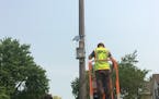 Minnesota Pollution Control Agency employee Jake Nelson installs an air pollution monitor.