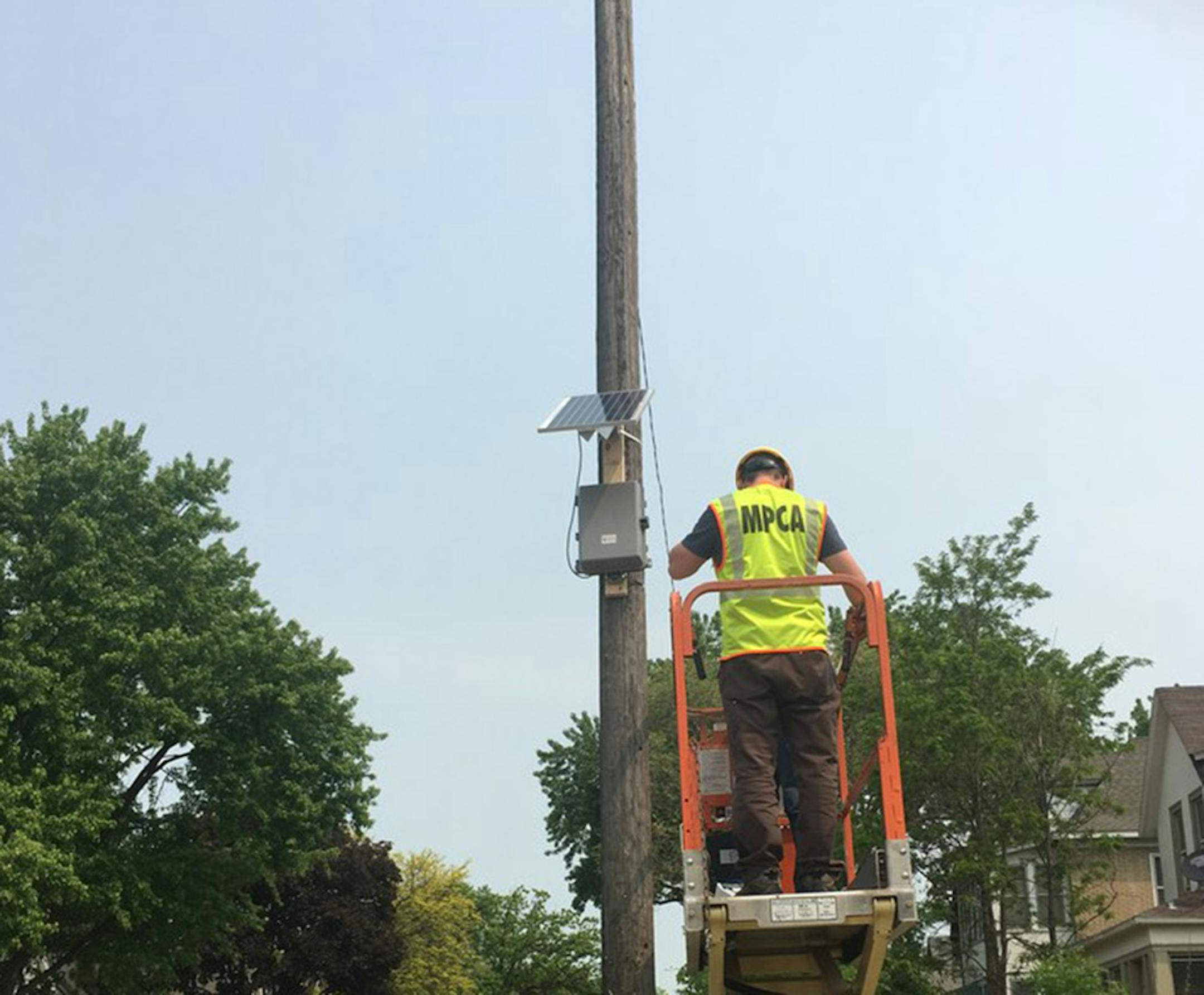 Minnesota Pollution Control Agency employee Jake Nelson installs an air pollution monitor.