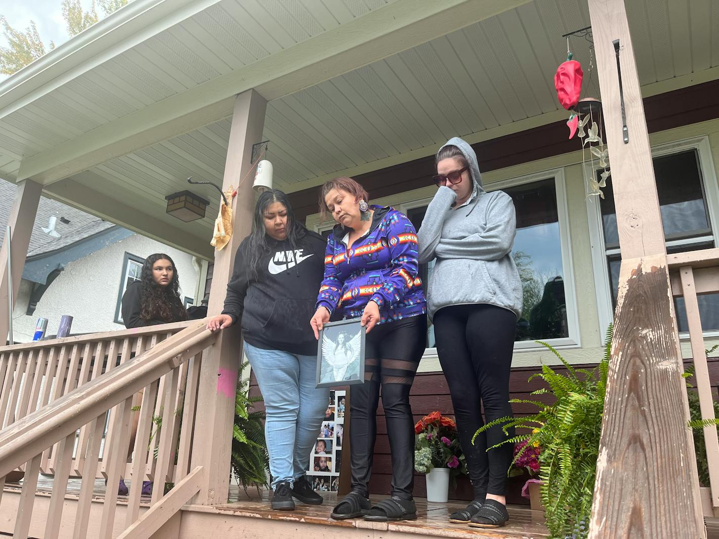 Marian Wright, surrounded by family, holds a photo of her little sister, Annalee Wright, who died protecting her children from a driver who ran a red light.