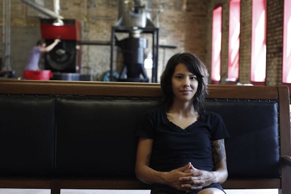 Director of coffee Stephanie Ratanas sits on a comfy couch in the office, lounge, and coffee bean roasting facility of Dogwood Coffee Co. in Minneapol
