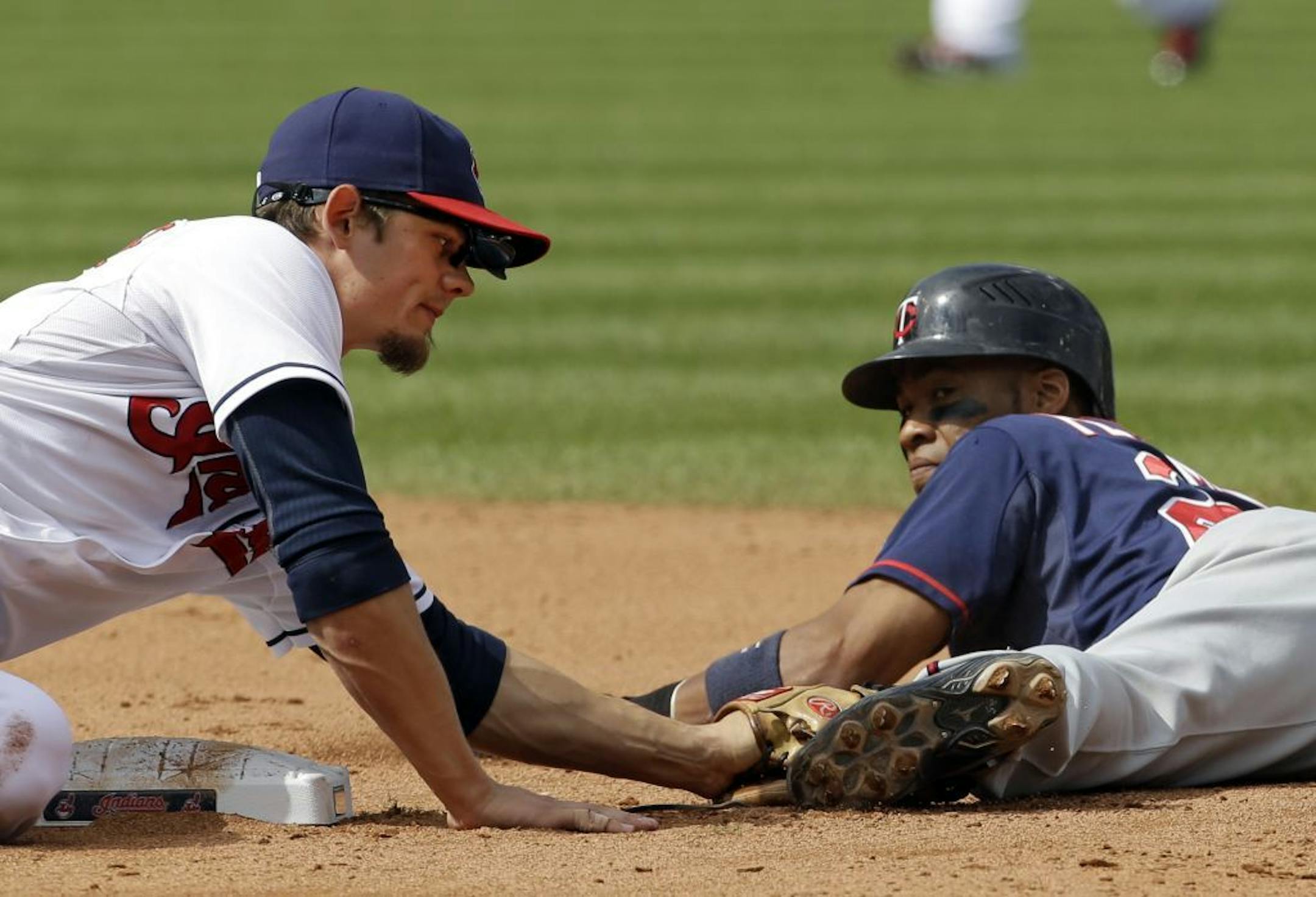 Cleveland Indians shortstop Brent Lillibridge, left, tags out Minnesota Twins' Pedro Florimon trying to steal second in the seventh inning of a baseball game Thursday, Sept. 20, 2012, in Cleveland.