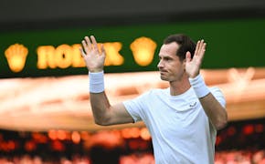 Andy Murray of Great Britain waves to the crowd on Centre Court following the Gentlemen’s Doubles first round match with Jamie Murray against Rinky 