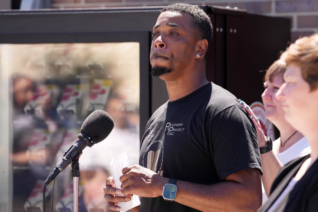 Christopher Burks, a program director at the Twin Cities Recovery Project, becomes emotional as he recounts a time naloxone saved him from a fatal overdose, at a news conference to unveil the city’s first free naloxone vending machine.  