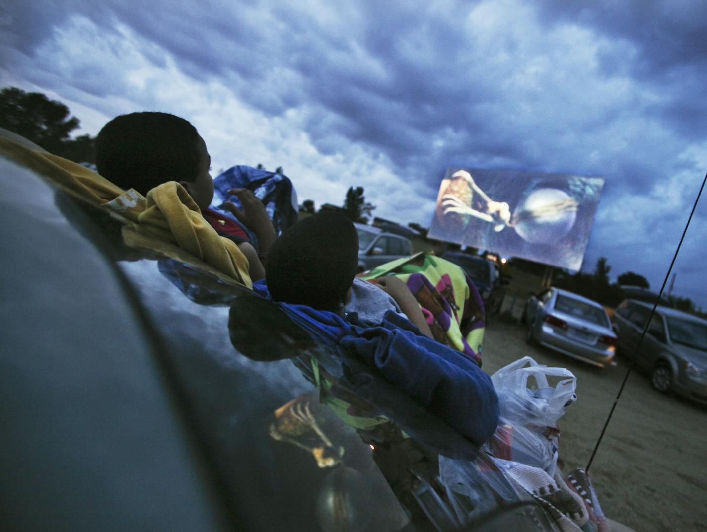 Maleec Sellner, 10, left, and his brother Tori, 6, of Hastings, used the hood of the family's car for a seat while taking in the double feature of Ice Age: Continental Drift and Brave Friday, July 13, 2012, at the Cottage View Drive-In, Friday, July 13, 2012, in Cottage Grove, MN.] (DAVID JOLES/STARTRIBUNE) djoles@startribune.com Summer in the City series at the Cottage View Drive-In where Ice Age: Continental Drift and Brave were playing.**Maleec and Tori Sellner,cq