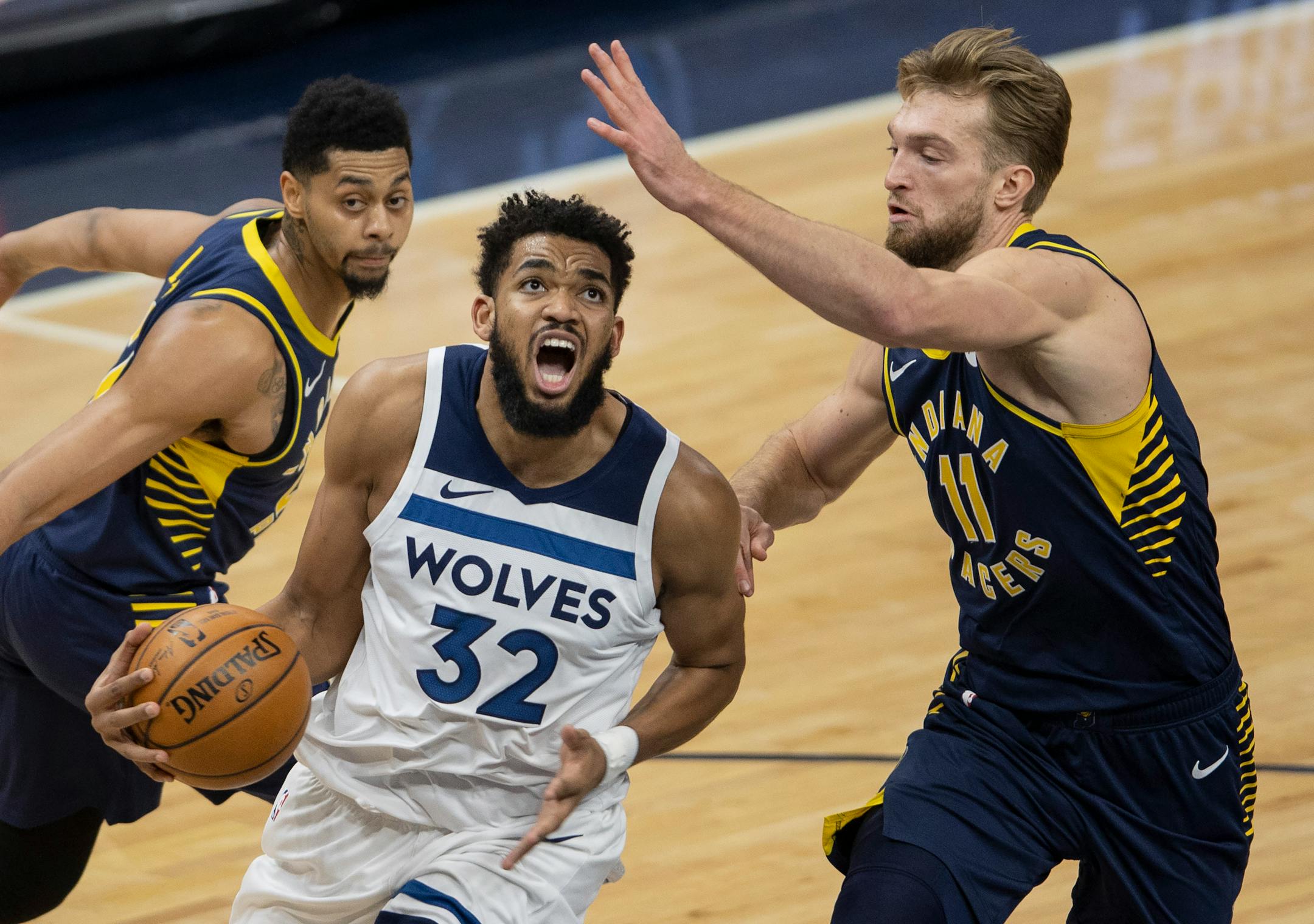 Minnesota Timberwolves Karl-Anthony Towns (32) was defended by Domantas Sabonis (11) of the Indiana Pacers in the fourth quarter.
