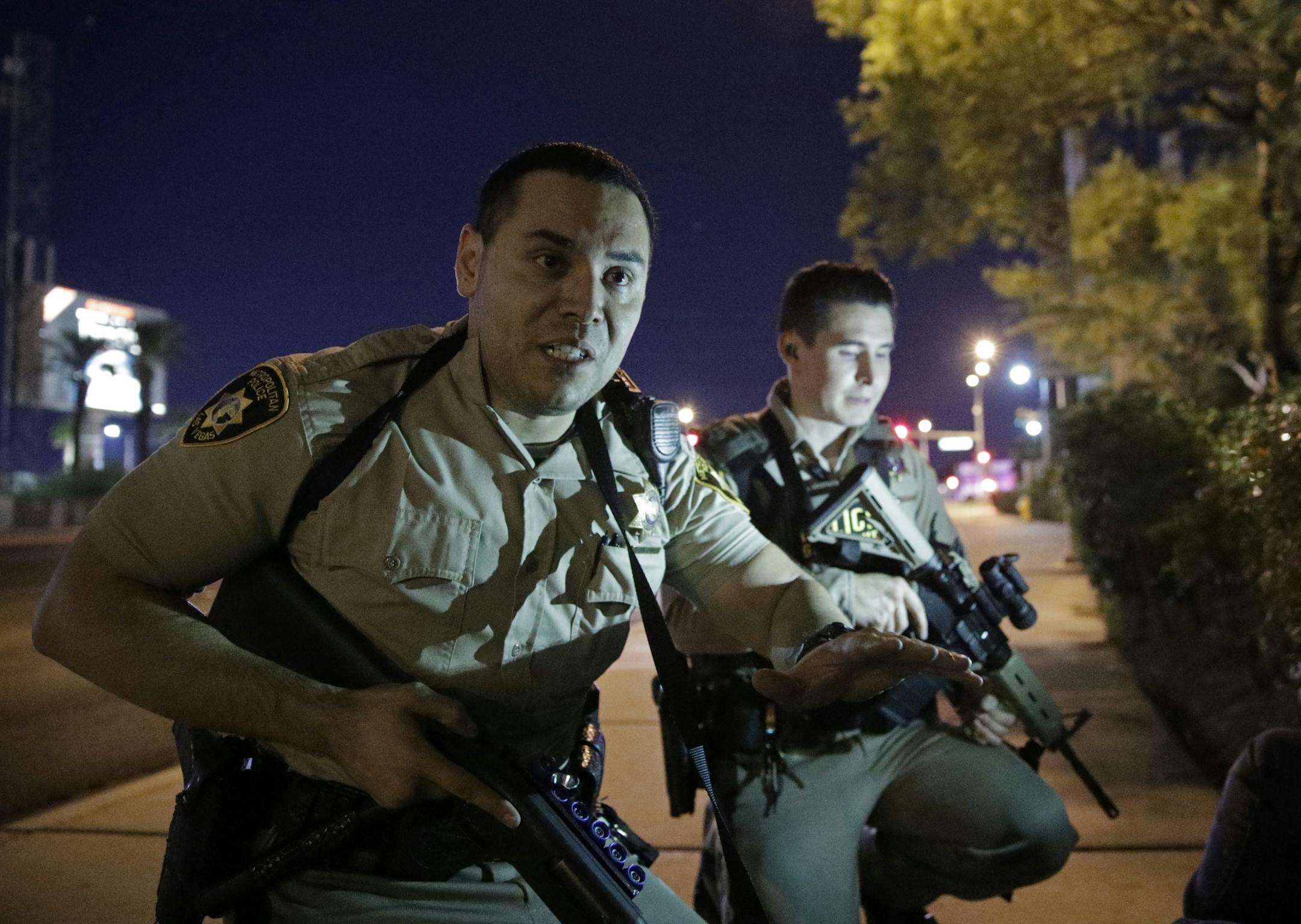 Police officers advise people to take cover near the scene of a shooting near the Mandalay Bay resort and casino on the Las Vegas Strip, Sunday.